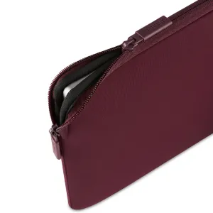 Housse Pipetto Classic Fit bordeaux pour MacBook, avec fermeture zippée et doublure douce, partiellement ouverte sur fond blanc