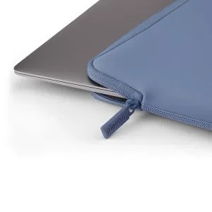 Pipetto Classic Fit Sleeve bleu clair, une housse fine zippée pour MacBook, avec un ordinateur portable argenté partiellement inséré