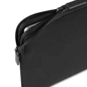 Pipetto MacBook-Hülle in Schwarz mit Reißverschluss, teilweise geöffnet, um einen silbernen Laptop im Inneren zu zeigen