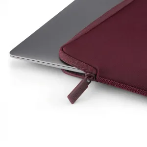 Housse Pipetto bordeaux pour MacBook Pro avec fermeture zippée, recouvrant partiellement un ordinateur portable argenté
