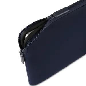 Pipetto tumesinine MacBooki ümbris kahesuunalise luku ja polsterdatud sisemusega, osaliselt avatud valgel taustal
