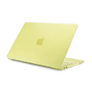 Pipetto genomskinligt hårt skal till MacBook på en ljusgul laptop, med Apple-logotypen och urtag för portar synliga.